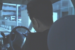 路中したワゴン車の中で凝った首を動かす風俗店経営者・津田